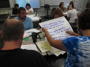 Venice High School English teachers, from left, Larry Burke, Kathleen Jones and LaRay Biziawski write a learning goal at a recent Common Core training. Venice High School assistant principal Joshua Leinweber, in the blue shirt, joined them.
