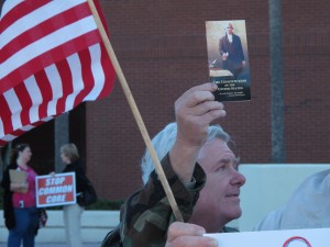 A man holds up a copy of the Constitution to oppose Common Core before a State Board of Education meeting in Orlando.