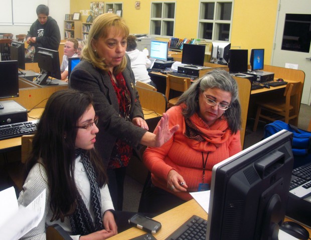 Miami Beach Senior High college adviser Maria Sahwell helps Anahi Hurtado, left, and her mother fill out the FAFSA.