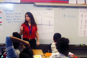Frances B. Tucker Elementary School 5th grade math teacher Yaliesperanza Salazar stands in front of an example of a line plot.