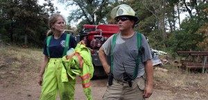 Christie Smith, a full-time nurse and volunteer firefighter with the Cedar County Fire Department, and David Thompson, safety officer with the Slaughterville Fire Department, cool down after extinguishing a hotspot that flared east of Noble, Okla.