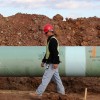 A worker inspects a segment of the Keystone Pipeline before it's lowered into a trench near Stroud, Okla.