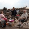 Stella and Jack Howard (left and right) with their daughter, Dawnelaina (center), sit with the remains of their Moore home. The Howards built this house after their last one was destroyed by the May 3, 1999, twister.