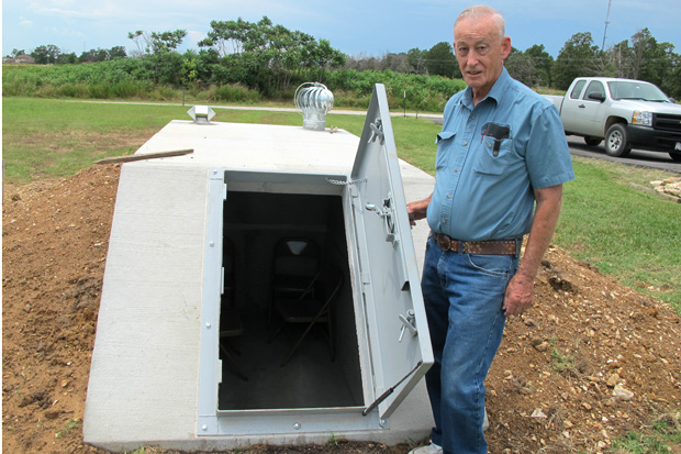 Wiley Robison shows off the new tornado shelter outside his home near Jay, Okla. 