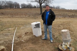 Justin Johnson, a wastewater treatment plant operator in Konawa, OK, stands near some of the town's water wells in December 2012. 