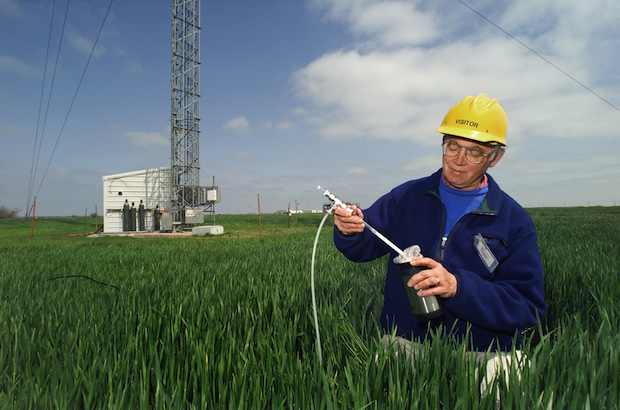 A scientist at the Southern Great Plains research facility in Lamont, Okla., transfers air samples to a flask for transport back to a lab. The new methane study used similar air sample data collected by the U.S. Department of Energy and NOAA during thousands of aircraft flights and from stationary towers throughout the country.