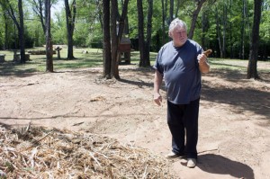 Homeowner Larry Huff holds a shard of Eastern Red Cedar, the handiwork of an Oklahoma County program that clears the flammable tree from private property.