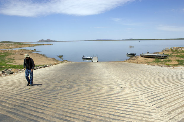 A fisherman walks up a dry boat dock at Tom Steed Reservoir. The lake is only 24 percent full and supplies water for Altus and other cities nearby.
