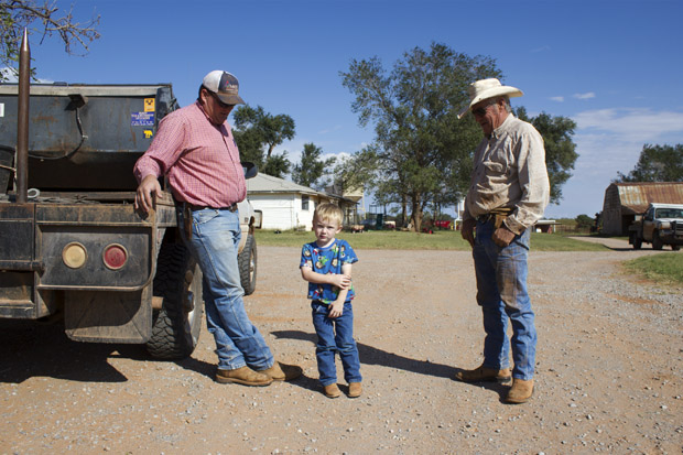 Monte Tucker, left, stands with his son and dad on the family's farm near Sweetwater, Okla.