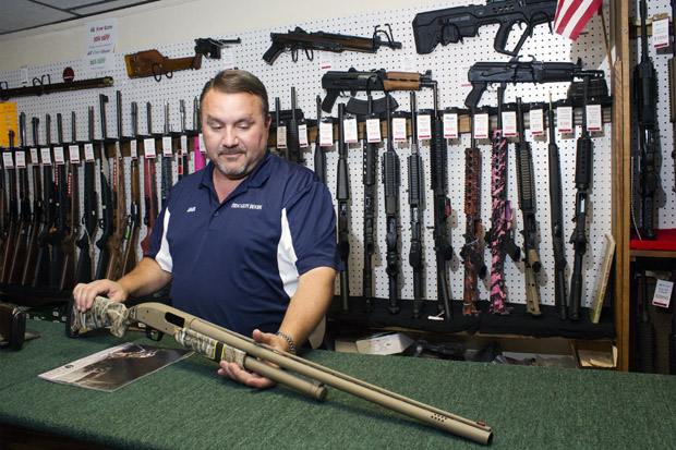Jack Barrett, owner of the BDC Gun Room in Shawnee, Okla., shows off a new shotgun model popular with hunters.