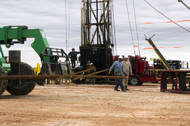 Oil-field workers lining up a section of pipe at a disposal well in Grant County, Okla.