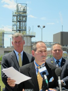 Secretary of the Department of Environmental Protection Michael Krancer in front of the idled Marcus Hook refinery. Krancer is holding a report by IHS recommending the re-use of the site to process Marcellus Shale gas.
