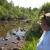 Laurie Barr points to an abandoned well located in the middle of a McKean County stream