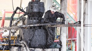   A drill worker covered in mud, shale, and drill cuttings seals off a well and cleans the blowout preventer at a Cabot Oil & Gas natural gas drill site in Kingsley, Pa.