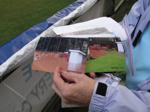 In this Sept. 15, 2011 photo, Paula Fenstermacher shows pictures in front of a FEMA office in Montoursville, Pa., of her parents' flood-damaged home along the Loyalsock Creek in Lycoming County.