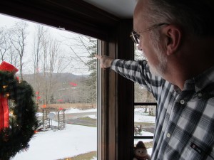 Chuck Winschuh points to a natural gas compressor station across the valley below his home in Dimock Township in Susquehanna County, Pa.