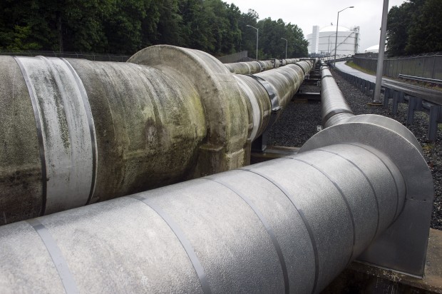 Pipes carry liquified natural gas to and from a holding tank, seen in background, at Dominion Energy's Cove Point LNG Terminal in Lusby, Md. Moody's expects projects already under construction--like this one-- will continue as planned.