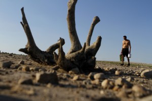 A man walks along Lake Travis after water receded during a drought  in Austin, Texas September 10, 2011. 