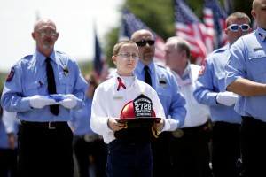 A helmet is carried in remembrance of a firefighter from the Abbott Volunteer Fire Department killed in the fertilizer plant explosion in West, Texas last year.