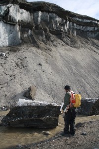 Research team member Jim O'Connor of the USGS inspects a block of ice calved off the Garwood Valley ice cliff.