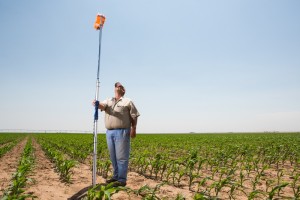 A device that transmits information on soil moisture in a cornfield belonging to David Ford (standing) a farmer near the Texas Panhandle town of Dumas. He is participating in a water-saving demonstration project.