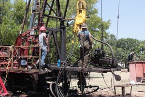 Roughnecks on drilling rig "working over" an old well along a city street in Kilgore. Hear more in our RADIO STORY 