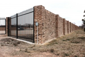 Gated gas: brick wall surrounds gas well site near neighborhoods on Fort Worth's east side