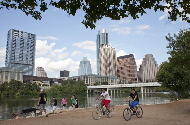 Cyclists pass beneath the downtown skyline on the hike and bike trail on Lady Bird Lake in Austin, Texas September 18, 2012. While traditionally an aesthetic pleasure, the lake could be used to help treat water. 