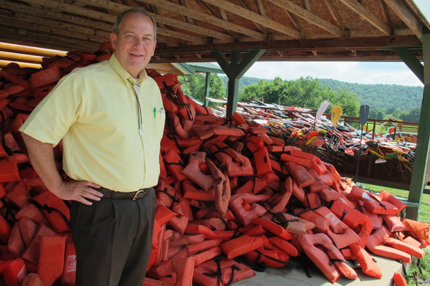 Oklahoma Scenic Rivers Commission Executive Director Ed Fite next to a mountain of life vests at the War Eagle Resort near Tahlequah, Okla. 