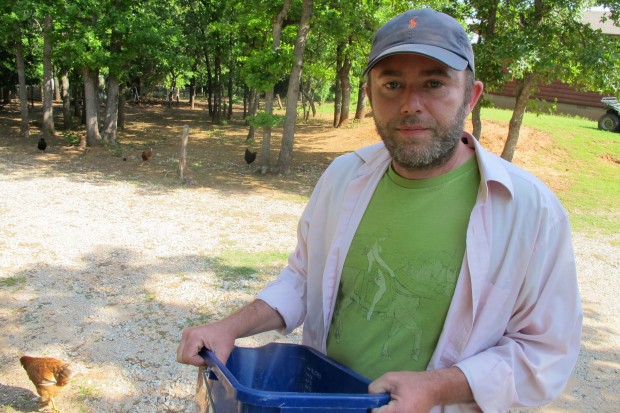 Dustin Green, owner of 10 Acre Woods farm near Norman, feeds a few of his 400 or so chickens. 