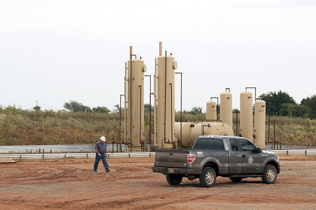 Gary Matli, a field inspector supervisor for the Oklahoma Corporation Commission, checks on a disposal well located near Guthrie, Okla.