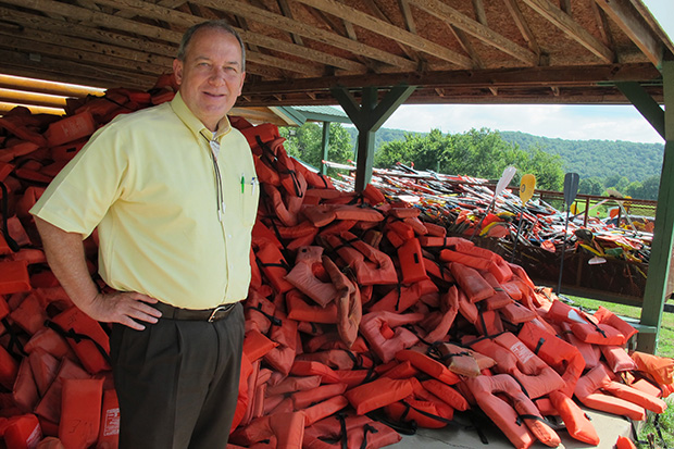 Ed Fite, executive director of the Oklahoma Scenic Rivers Commission, stands next to a mountain of life vests at one of the resorts on the Illinois River.
