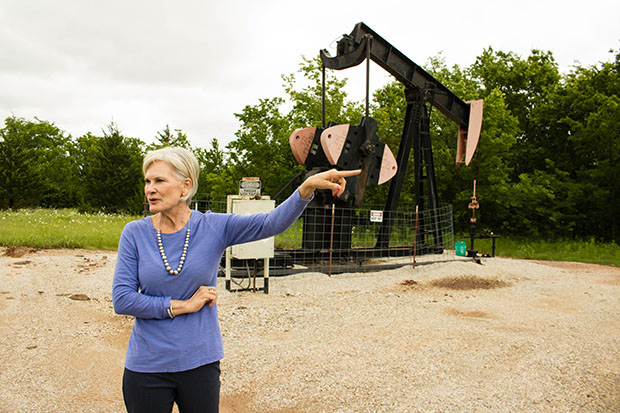Columbus Oil Company owner Darlene Wallace in the field with a "stripper well," which produces two-and-a-half barrels of oil a day. 