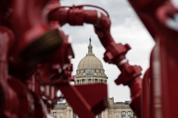 Service companies parked oil-field trucks and other equipment at the state capitol in a public demonstration as legislators debated a measure that would effectively increase taxes some oil and gas producers pay.