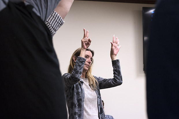 A demonstrator holds up seven fingers to send a message to a House committee that lawmakers should remove discounts and incentives so all oil and gas wells are taxed at 7 percent.