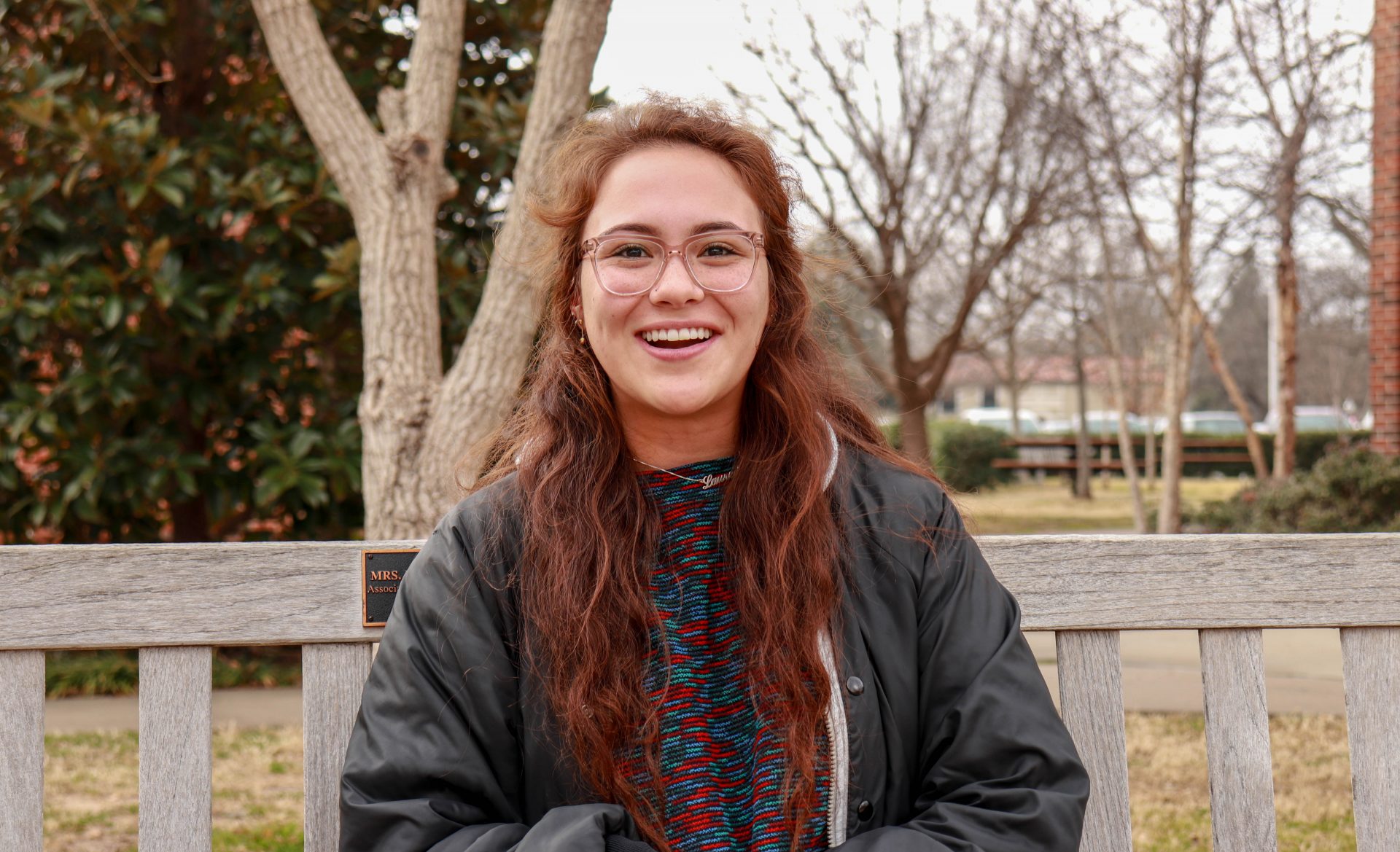 Lauren Atkins sits on a bench on the University of Oklahoma's campus.