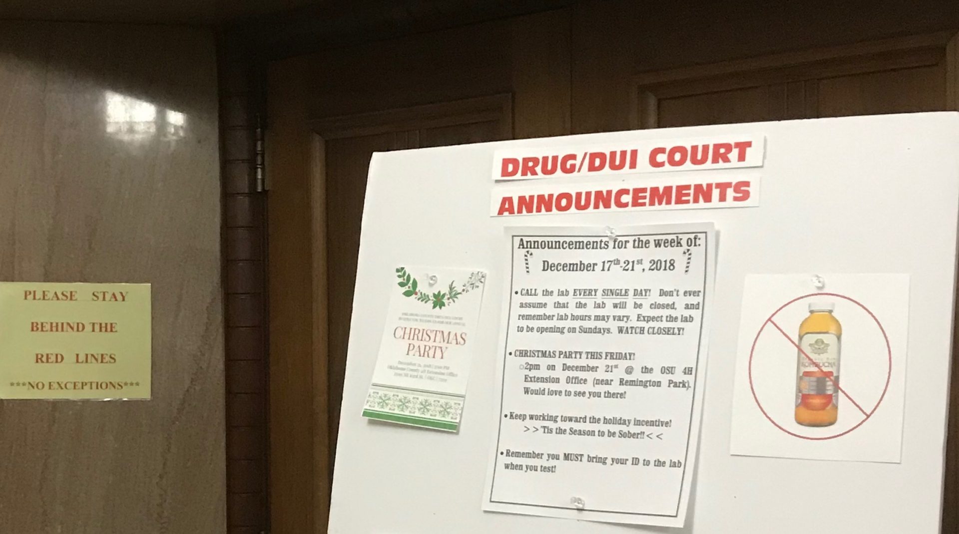 A white bulletin stands outside the Oklahoma County Drug Courtroom. It reminds participants they have to report to a lab for drug testing, and not to drink Kombucha. 