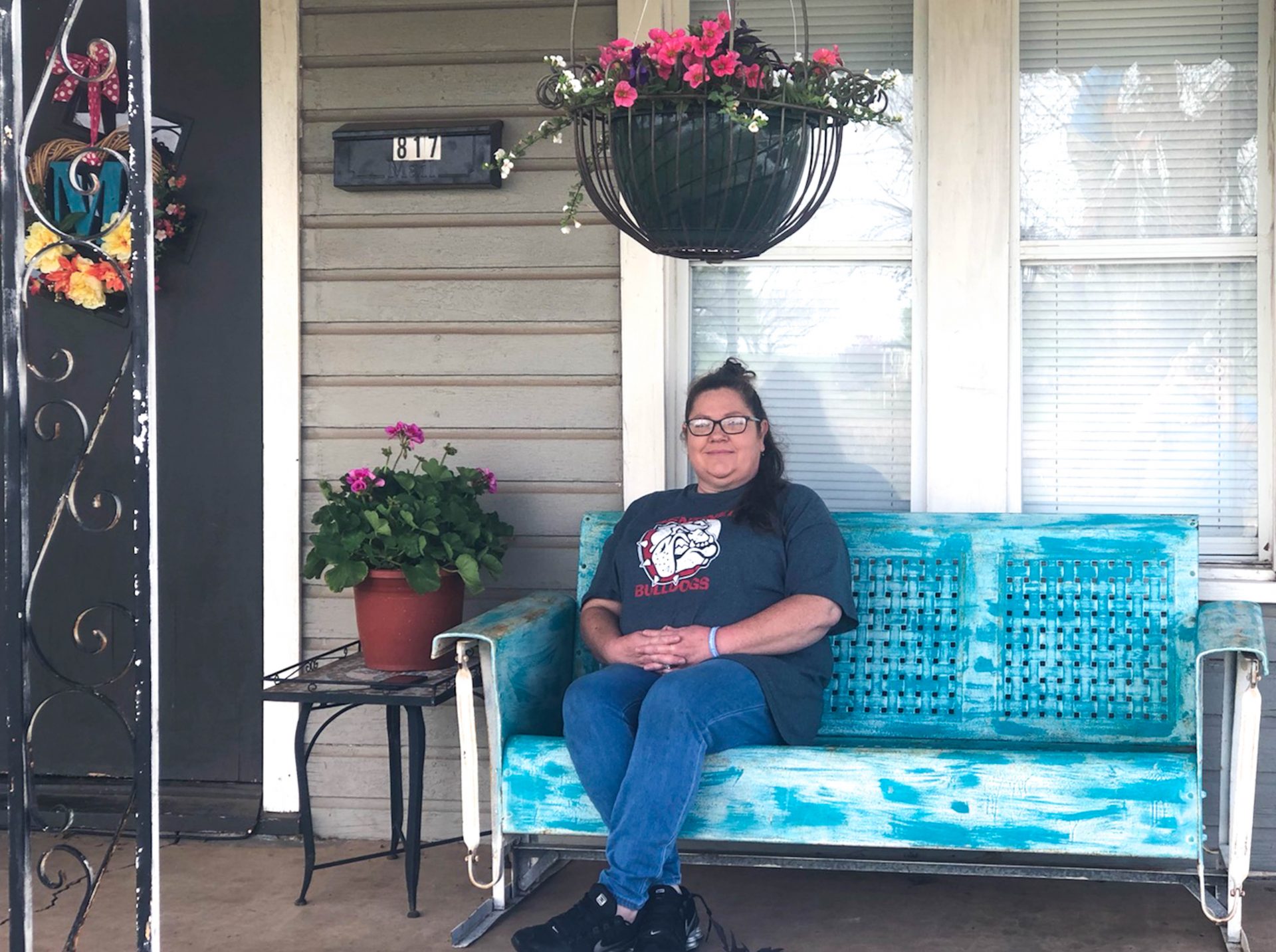 Sarah Morrow sitting on the porch of her house.