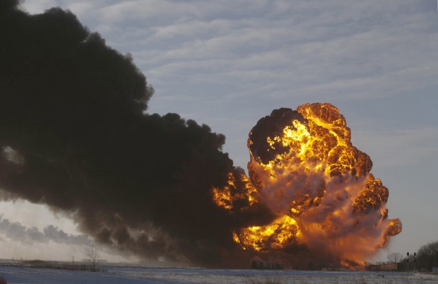 In this Dec. 30, 2013 file photo, a fireball goes up at the site of an oil train derailment in Casselton, N.D.  On Tuesday, March 31, 2015, Bryan Thompson, of Fargo, N.D., the engineer of the oil tanker train involved in the derailment, filed a complaint against BNSF Railway, accusing the railroad of negligence. Thompson says BNSF failed to properly inspect and maintain its equipment and failed to warn him of the dangers of hauling explosive oil tank railcars