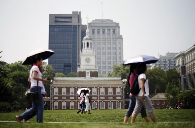 Tourists shield themselves with umbrellas in front of Independence Hall on Friday, July 19, 2013, in Philadelphia. An excessive heat warning is again in effect for the Philadelphia region.