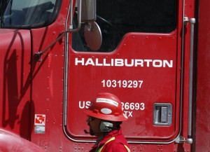 An unidentified worker passes a truck owned by Halliburton at a remote site for natural-gas in Colorado. 