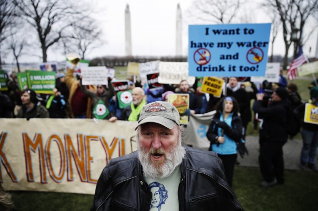 Hydraulic fracturing opponents, including Ray Kemble of Dimock, Pa., front, demonstrate before Gov, -elect Tom Wolf takes the oath of office to become the 47th governor of Pennsylvania, Tuesday, Jan. 20, 2015, at the state Capitol in 