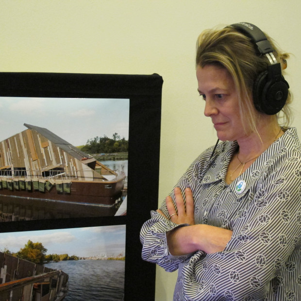 Bethany Wiggin, who runs Penn's program in environmental humanities listens to audio from the Date-um exhibit, which focuses on water quality in the lower Schuylkill river.