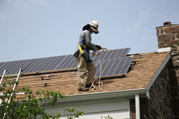 Patrick Whittaker of Solar States installs solar panels on the roof of a home in Bryn Mawr. 