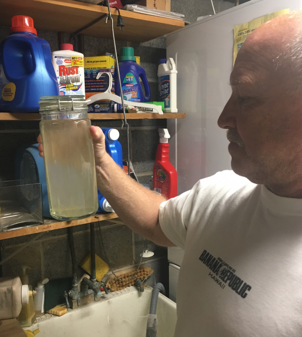 David Mano, a resident of Chester County's West Whiteland Township, holds a sample of water taken from his well after the  local aquifer was punctured by drilling for the planned Mariner East 2 pipeline. 