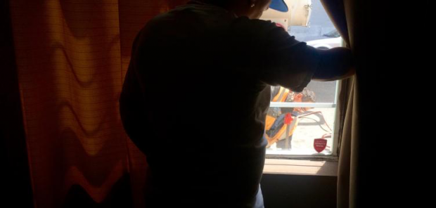 Manuel Ortiz looks out his living room window to the street construction outside his home.