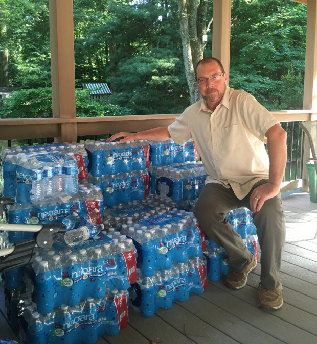 Benjamin Eckert, a resident of Chester County's West Whiteland Township, with some 30 cases of bottled water that Sunoco had delivered to his house after water from his well turned cloudy. Sunoco is drilling nearby for the planned Mariner East 2 pipeline, and hit the aquifer from which Eckert and his neighbors draw their water. 