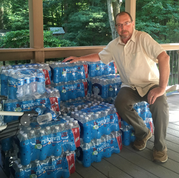 Benjamin Eckert, a resident of Chester County's West Whiteland Township, with some 30 cases of bottled water that Sunoco had delivered to his house after water from his well turned cloudy. Sunoco is drilling nearby for the planned Mariner East 2 pipeline, and hit the aquifer from which Eckert and his neighbors draw their water. 