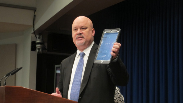 Scott Perry, Deputy Secretary of DEP's Office of Oil and Gas Management holds up an iPad.