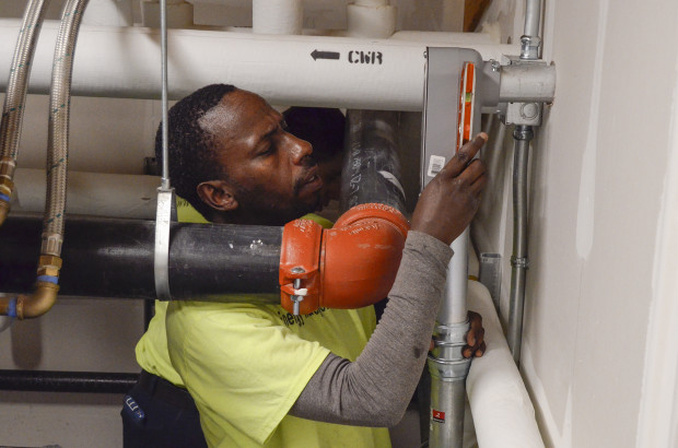 Richard Tumushime, an electrician with Pittsburgh-based Energy Independent Solutions, works with a crew to put the finishing touches on wiring a solar panel system at the new Forest Hills Municipal Building.